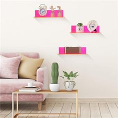 three pink shelves on the wall above a couch and coffee table in a living room