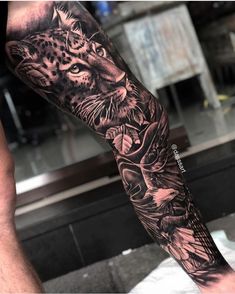 a man with a tattoo on his arm that has a leopard and flowers on it