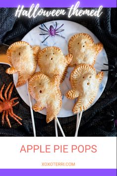 four small pastries on a plate with toothpicks in the shape of crabs