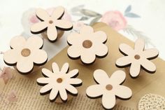 four wooden flowers on top of an open book