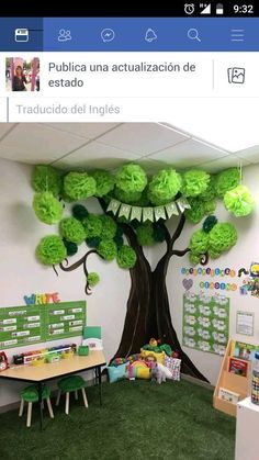 an office decorated in green and white with a tree on the wall, surrounded by children's toys