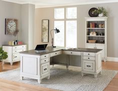 a white desk sitting on top of a hard wood floor next to a large window