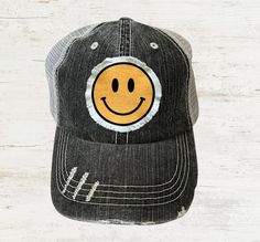 Cute women's smiley face hat. Unisex distressed gray trucker hat with gray adjustable(velcro) mesh backing. Patch is handmade with frayed edges. One size fits most. - Wholesale pricing available on any order of 20+ hats. Please message us if you're interested in wholesale options & pricing and we can discuss the options. Trendy Curved Brim Hat With Smiley Face, Adjustable Fun Hat With Smiley Face, Casual Smiley Face Hat With Curved Brim, Adjustable Baseball Cap With Smiley Face, Cute Adjustable Hat With Smiley Face, Trendy Smiley Face Hat With Curved Brim, Adjustable Smiley Face Fun Baseball Cap, Trendy Smiley Face Baseball Cap With Curved Brim, Fun Adjustable Trucker Hat With Smiley Face