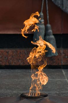 a fire that is on top of a metal object in the air with it's flames