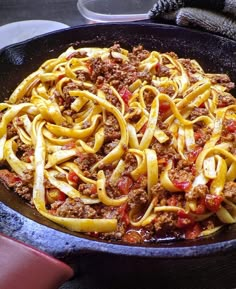 a skillet filled with pasta and meat