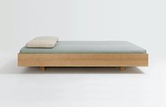 a bed with a wooden headboard and foot board in front of a white wall