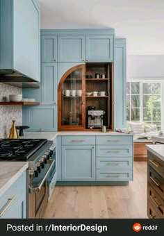 a kitchen with blue cabinets and wooden floors