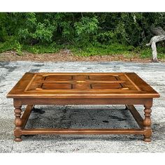 an old wooden coffee table sitting in front of some bushes