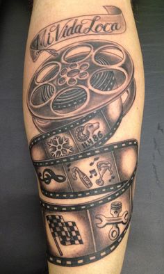 a man's leg with a tattoo on it that has film reels and movies