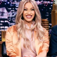 a woman with long blonde hair sitting in front of a man on the tonight show