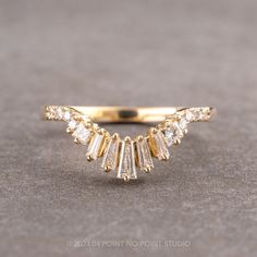 a yellow gold ring with five baguettes on the top and two rows of diamonds in the middle