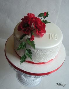 a white cake with red flowers on top