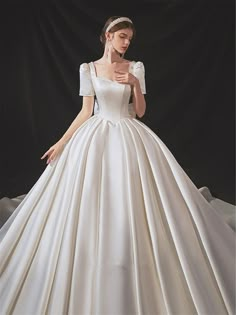 a woman in a white wedding dress is posing for the camera with her hands on her hips