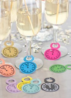 there are four glasses with different colored clocks on them and one has straws in it