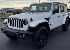 a white jeep parked in a parking lot