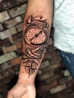 a man with a compass tattoo on his arm