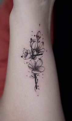 a black and white flower tattoo on the ankle