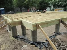 some pipes are laying on the ground in front of an unfinished structure that is being built