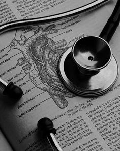 a stethoscope laying on top of an open book with medical diagrams in it