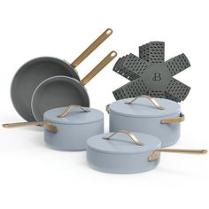 an assortment of pots and pans with wooden spoons in them on a white background