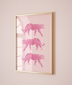 three pink cheetah silhouettes in a gold frame against a pale pink wall