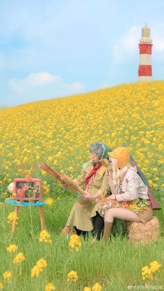 two people sitting on a bench in front of a field with yellow flowers and a lighthouse