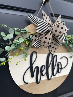 a wooden sign that says hello hanging on a door