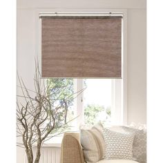 a living room with a couch, chair and window covered in roman blind shades on the windowsill