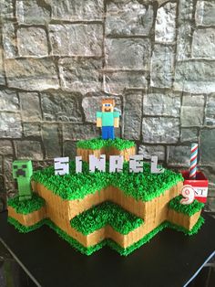 a cake that is made to look like a minecraft hill with grass on top