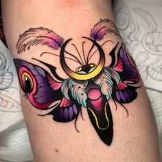 a colorful tattoo design on the leg of a woman's thigh, with feathers flying around