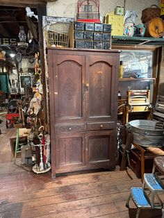 an old wooden armoire sitting inside of a shop