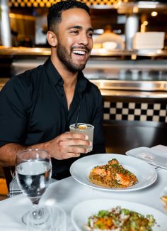 a man sitting at a table with food and drinks