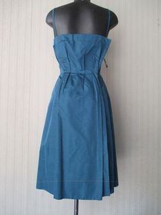 "Oariginal ustom made 50s satin dress. Teal coloured. Spaghetti straps. Close fitting on bust and wide bottom with pleats (pic.1). Back tail (pic.3). Party dress. Mint conditions. It fits size 6-8 US Size 38-40 EU Measurements: (lay flat and double chest and waist)) Chest 37.7\" waist 29\" length (from armpit) 32.2\" Bel vestito da cerimonia anni 50 color verde petrolio, con spallini. Fatto su misura, veste una taglia 44 ca. Stretto in vita e ampio con pieghe sotto. Dietro ha un pezzo di tessuto Vintage Satin Dress With Pleated Bodice, Fitted Retro Satin Dresses, Retro Fitted Satin Dress, Sleeveless Blue Dress For Vintage Fashion, 1950s Style Blue Formal Dress, Blue Formal Dress In 1950s Style, Blue 1950s Style Formal Dress, Formal 1950s Style Blue Dress, Formal Blue 1950s Style Dress