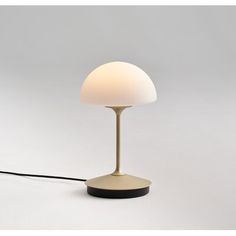 a lamp that is on top of a white surface with a cord attached to it