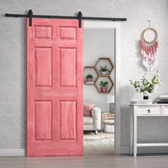 an open pink door in a living room with white walls and wooden flooring on the side