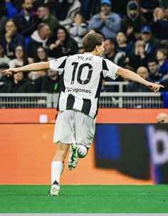 a soccer player is running on the field with his arms outstretched in front of an audience