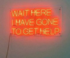 a neon sign that says wait here i have gone to get help on the wall