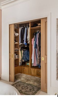 an open closet with clothes hanging in it