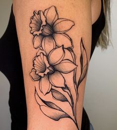 a black and white flower tattoo on the right arm, with flowers in it's center