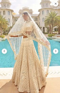 a woman standing in front of a pool wearing a wedding dress