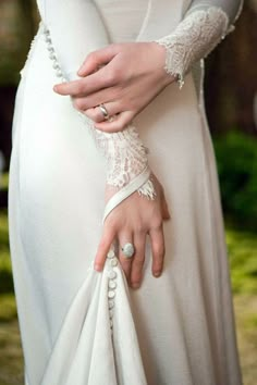 a close up of a person wearing a wedding ring and holding on to her arm