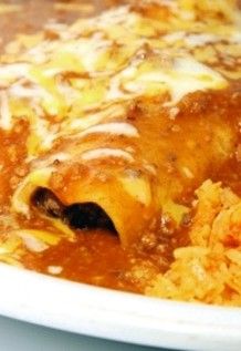 a close up of a plate of enchilada soup with rice on the side