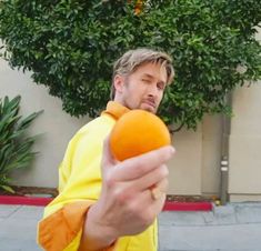 a man holding an orange in his right hand