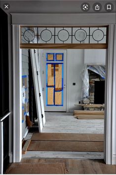 an open door leading into a room with white walls and wood flooring in the foreground