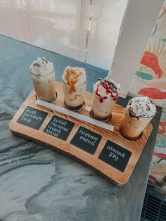 three desserts are sitting on a wooden tray