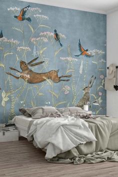 a bed room with a neatly made bed next to a wall mural on the wall