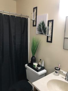 a bathroom with a black shower curtain and white sink