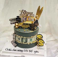 a birthday cake decorated with money and gold decorations