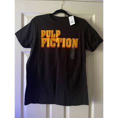 a black t - shirt with the word pulp fiction on it hanging from a door