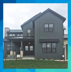 a large gray house sitting on top of a lush green field